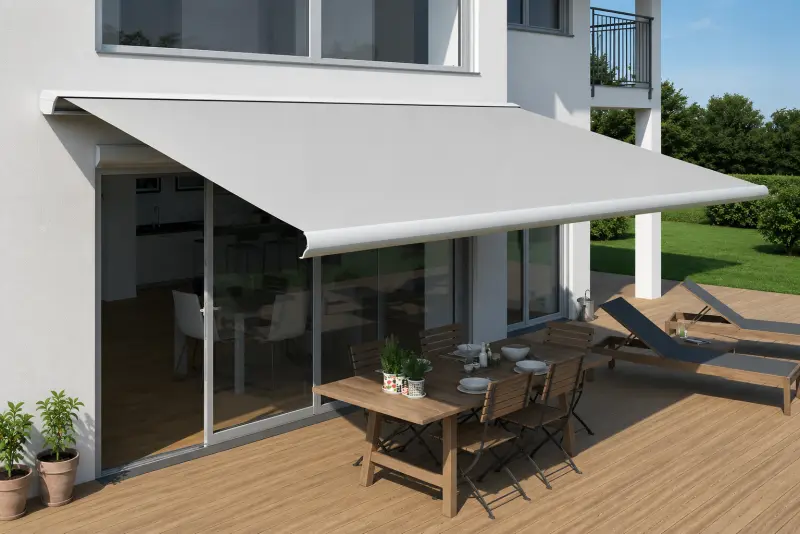 Ausgefahrene Gelenkarmmarkise über einer sonnigen Terrasse mit Esstisch